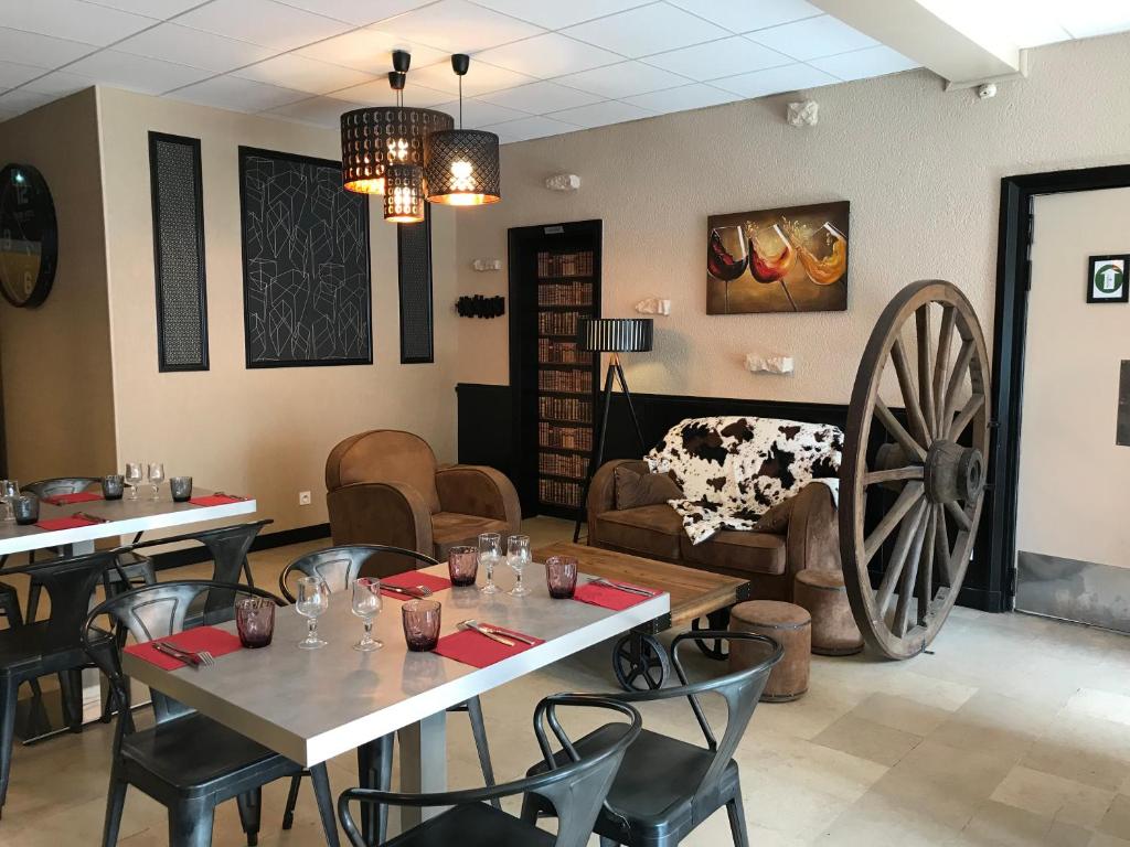 een restaurant met een tafel en een groot wiel bij Hotel du Centre - Restaurant le P'tit Gourmet in Tonnerre