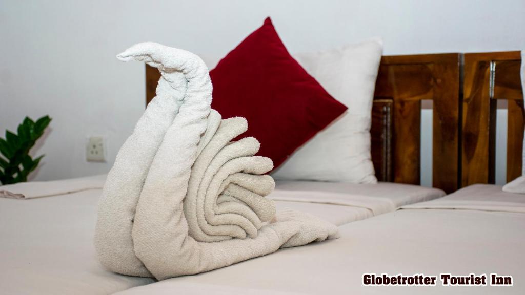 a towel animal sitting on top of a bed at Globetrotter Tourist Inn in Sigiriya