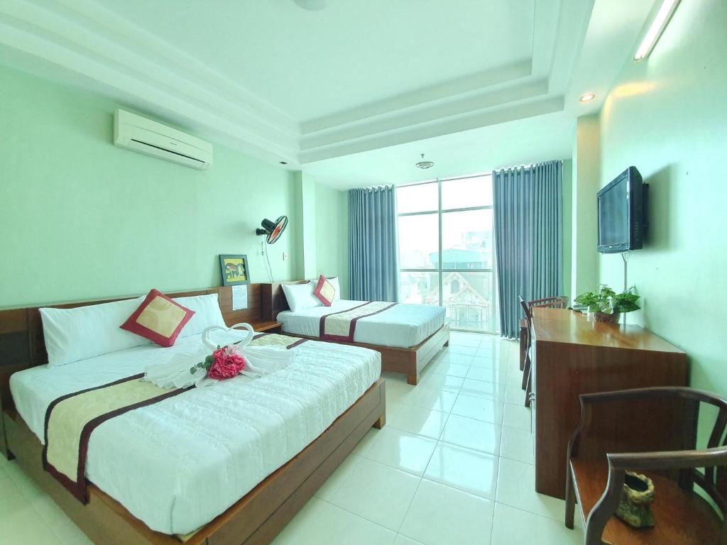 um quarto de hotel com uma cama, um sofá e uma televisão em Khách sạn Trường Sơn em Ho Chi Minh