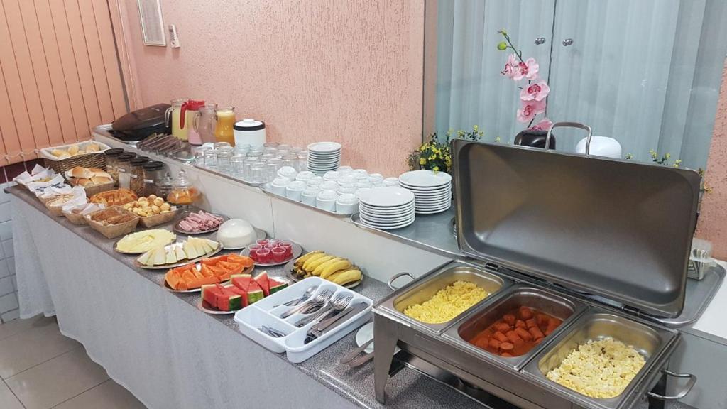 una línea de buffet con muchos tipos diferentes de comida en Alvimar Hotel, en Sobradinho