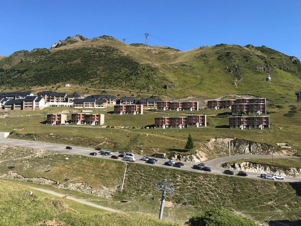 eine Straße mit Autos, die an der Seite eines Berges geparkt sind in der Unterkunft Gite Bel Air La Mongie in La Mongie