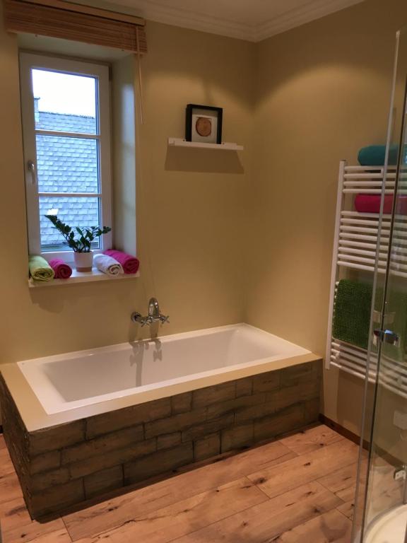 a bath tub in a bathroom with a window at Landhaus Roidergütl in St. Wolfgang