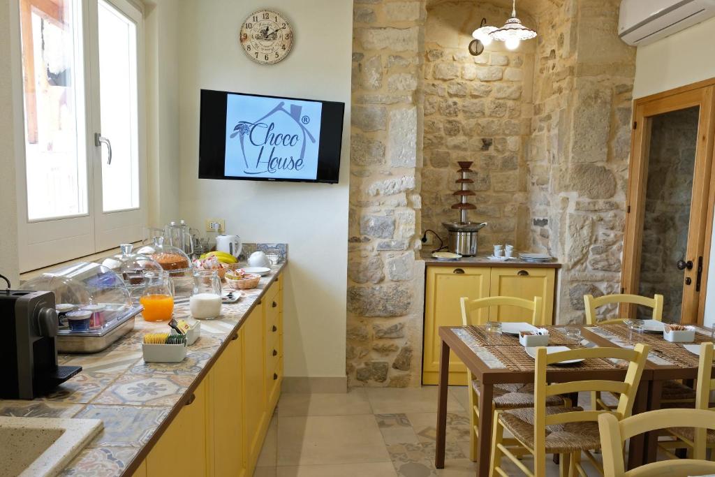 a kitchen with a table and a clock on the wall at ChocoHouse in Ragusa