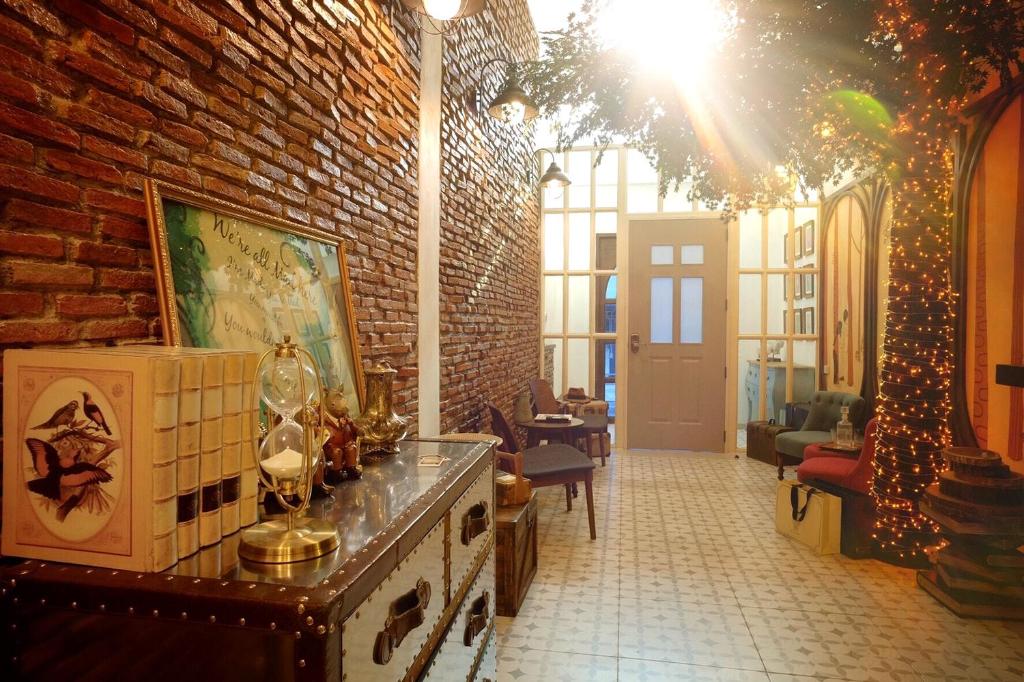 - un salon avec un mur en briques et un arbre de Noël dans l'établissement Hide and Seek Boutique Hometel, à Bangkok