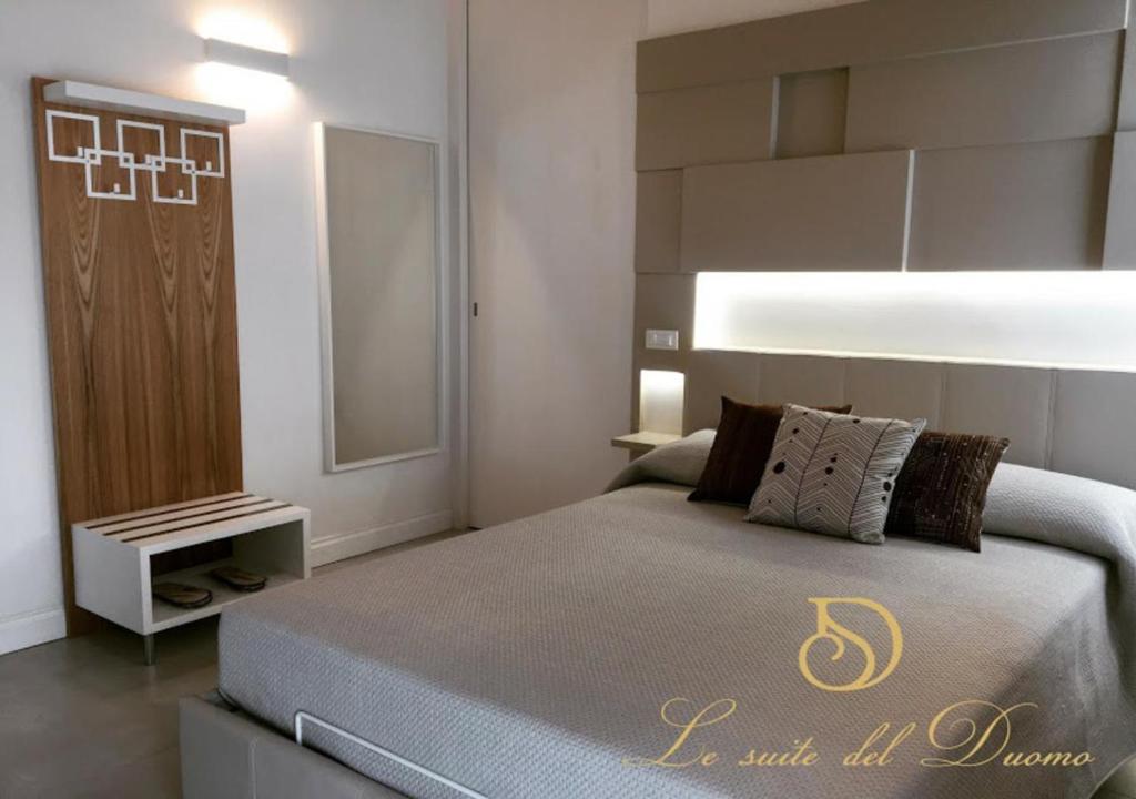 a bedroom with a large bed and a mirror at Le Suite del Duomo in Cava deʼ Tirreni