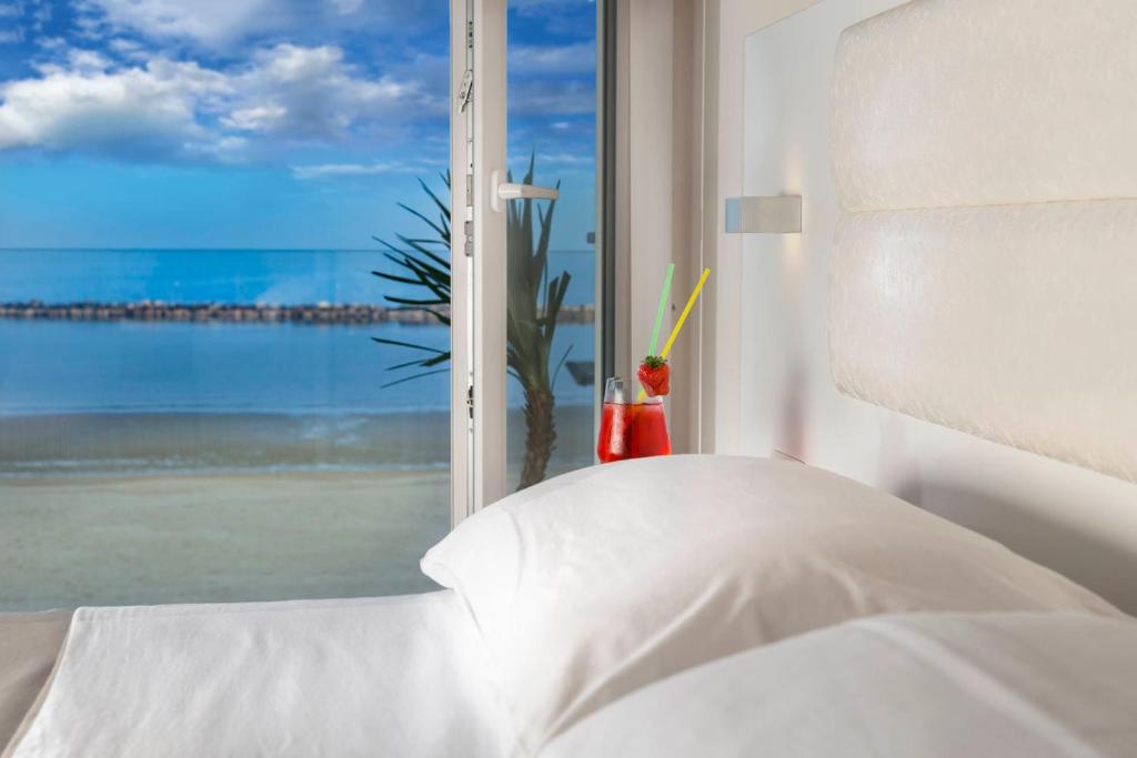 una camera da letto con finestra affacciata sull'oceano di White Suite & Apartments a Bellaria-Igea Marina