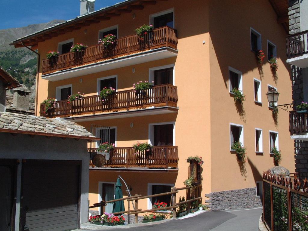 budynek z doniczkami na balkonach w obiekcie Residence Au Vieux Grenier w mieście Cogne