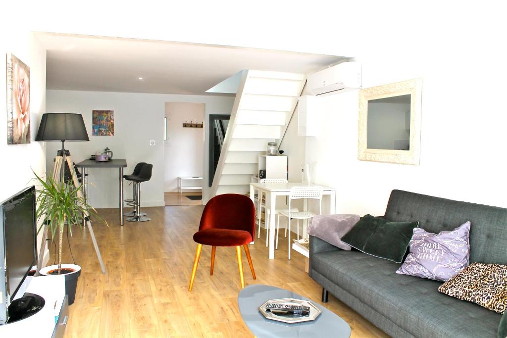 ein Wohnzimmer mit einem Sofa und einem Tisch in der Unterkunft T3 L'Olivier & Jardin 1 à 4 Pers à Villa Terra in Balma