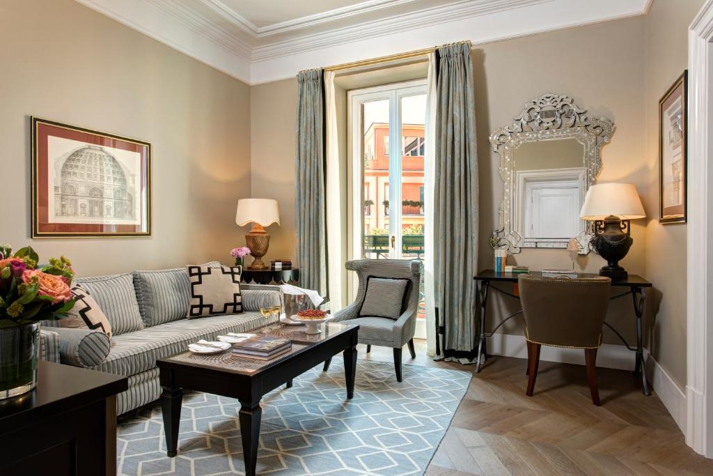 
a living room filled with furniture and a large window at Rocco Forte Hotel De La Ville in Rome
