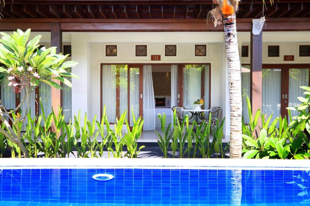 a house with a swimming pool in front of a house at Kaniya bali in Nusa Dua