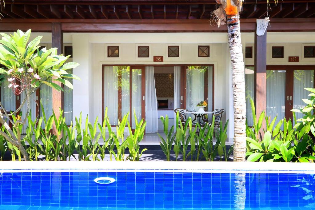 een huis met een zwembad voor een huis bij Kaniya bali in Nusa Dua