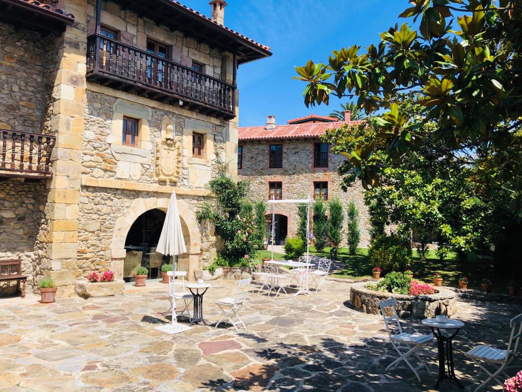 an outdoor patio with an umbrella and a building at Posada La Torre de La Quintana in Liendo