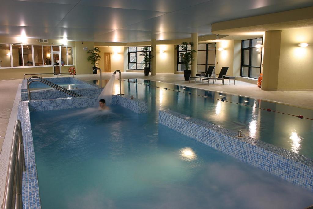a large swimming pool with a person in the water at Amber Springs Hotel in Gorey