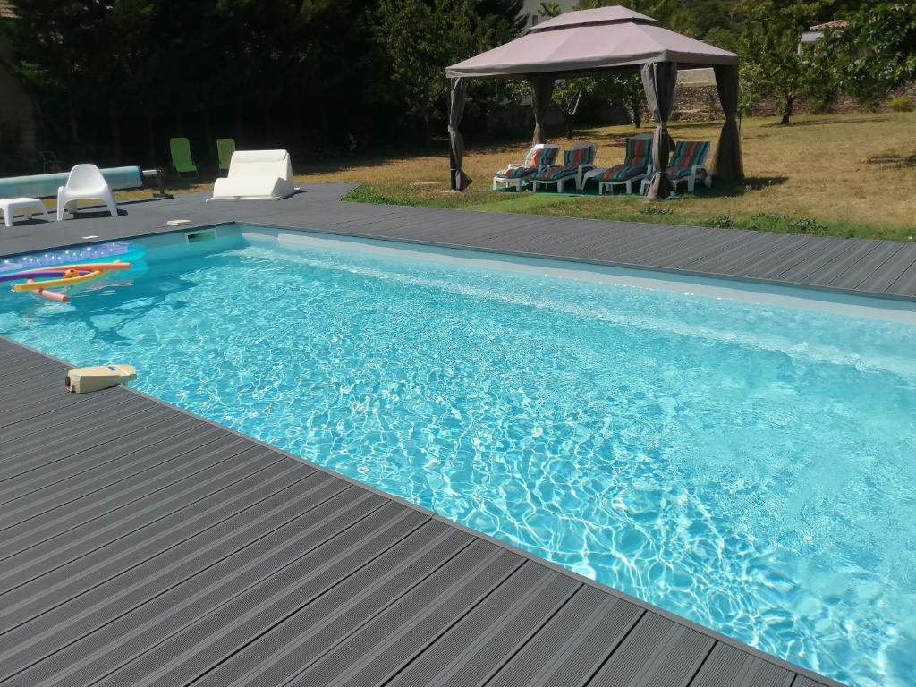 a swimming pool with a gazebo in a yard at L accueillante B&B in Bédarieux