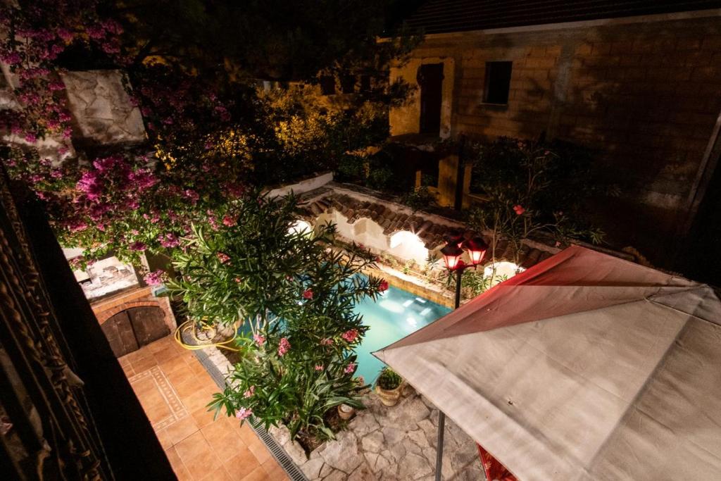 uma vista superior de uma piscina com flores e um guarda-sol em Guest House Villa Barbara em Orebić