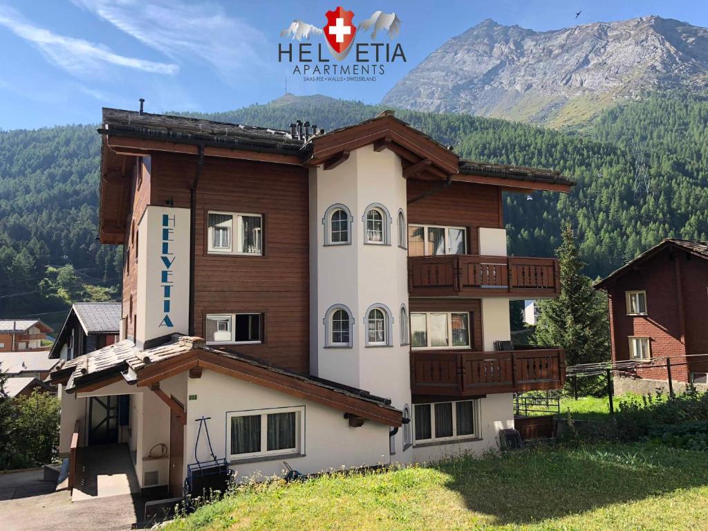 a building with a mountain in the background at Helvetia Apartments in Saas-Fee