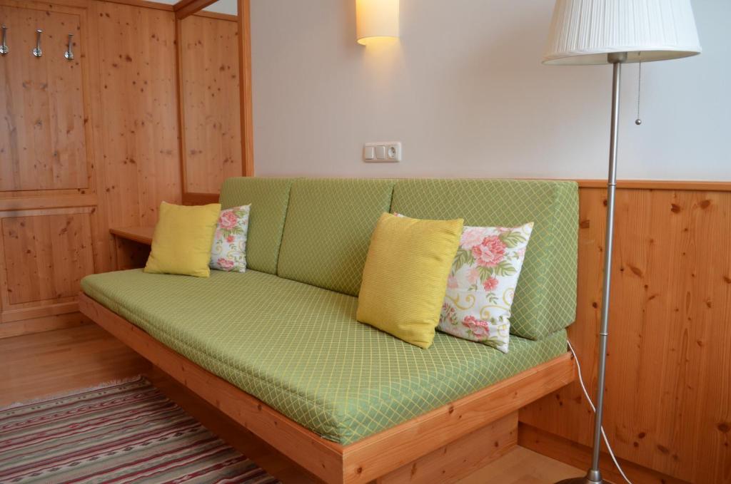 a green couch with pillows on it in a room at Hotel Gasthof König in Kremsmünster