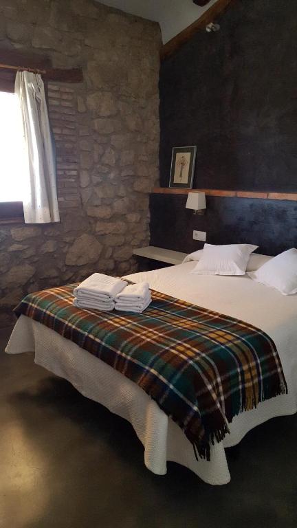 Un dormitorio con una cama con una manta. en Casa Baluard de Ferreres, en Olvan