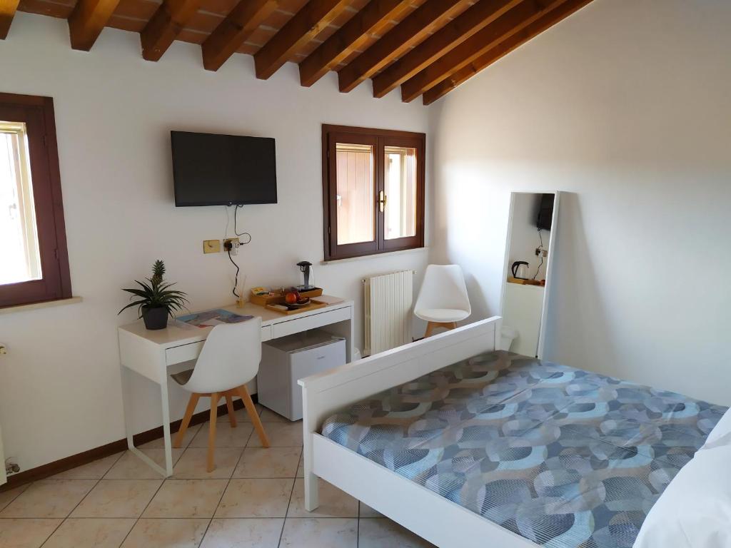 1 dormitorio con 1 cama, escritorio y TV en Carducci 49 en Mantova