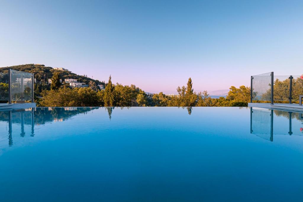 une piscine d'eau bleue et une montagne en arrière-plan dans l'établissement Villa OMNIA - Kommeno bay, à Dassia