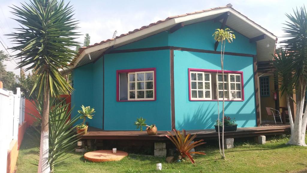 una casa azul con un banco delante en BANGALÔ NATUREZA, en Florianópolis