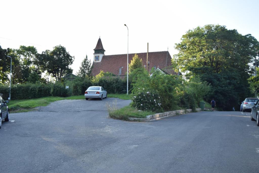 un parking avec des voitures garées devant un bâtiment dans l'établissement Central Appartment St's Martin Church, à Braşov