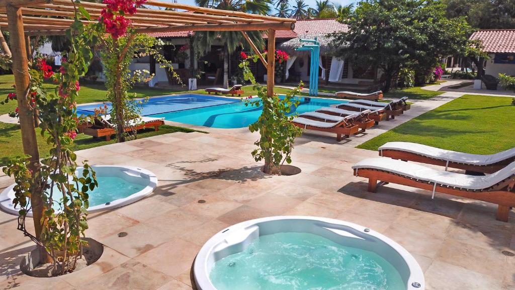 a swimming pool with a hot tub in a yard at Tucano Pousada in Cumbuco