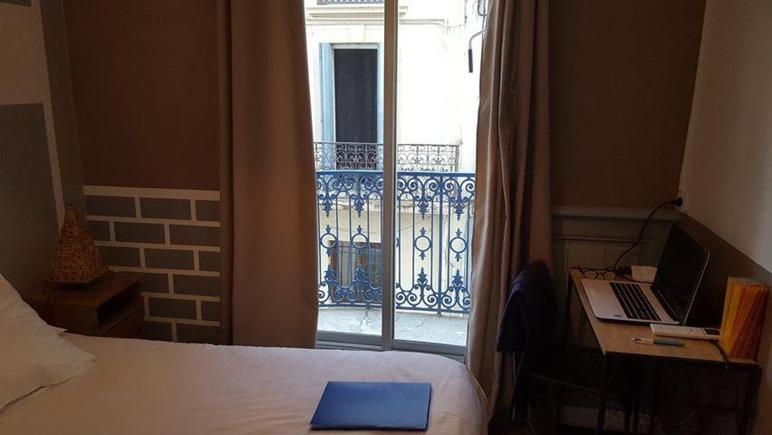 Un pat sau paturi într-o cameră la Hôtel Confort