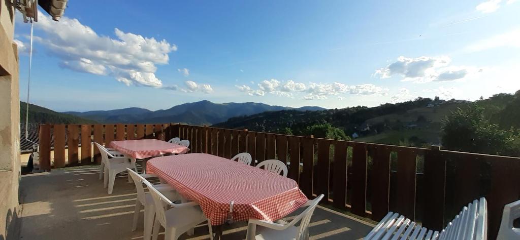 two tables and chairs on a balcony with mountains at Maison Bellevue in Geishouse