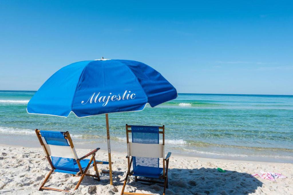 zwei Stühle und ein Sonnenschirm am Strand in der Unterkunft Majestic Beach Resort in Panama City Beach