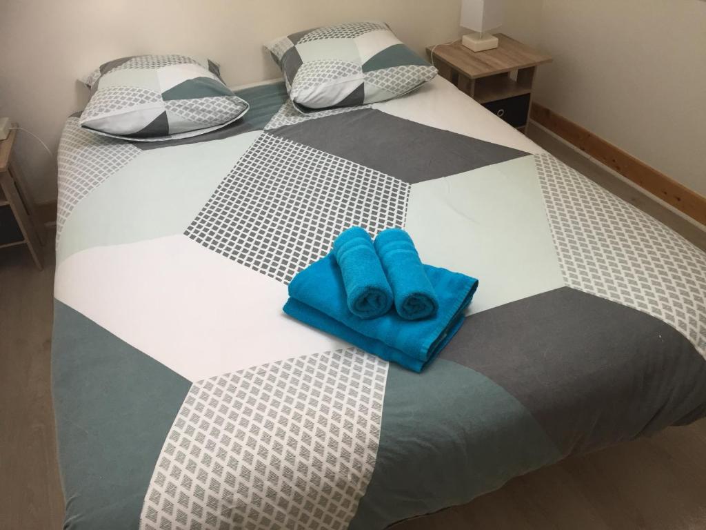 a bed with two blue towels sitting on it at Maison de ville 3 chambres 3 salles d&#39;eau parking 2 places in Romorantin