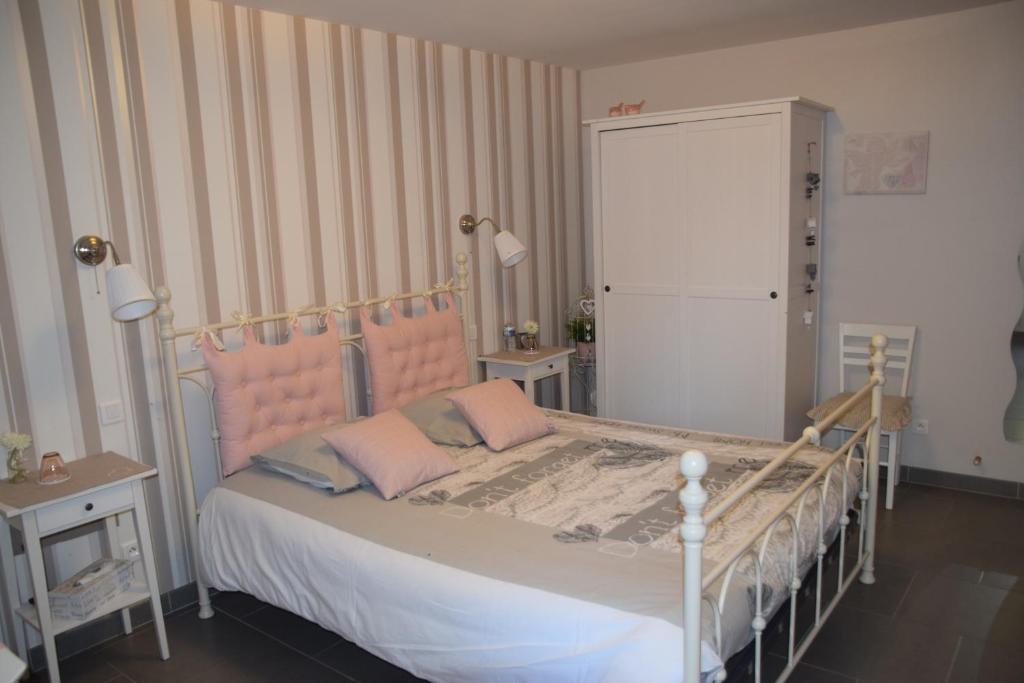 Schlafzimmer mit einem Bett mit einem rosa Kopfteil in der Unterkunft Au cœur de la lys in Merville
