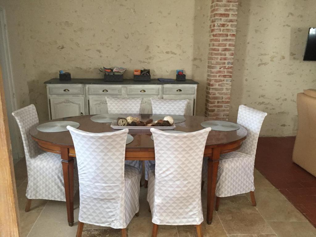 a dining room table with white chairs around it at Maison de ville 3 chambres 3 salles d&#39;eau parking 2 places in Romorantin