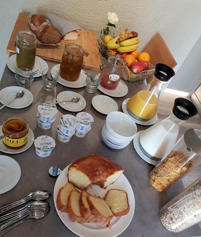 a table topped with plates of bread and fruit at Hôtel du Cygne in Bevaix