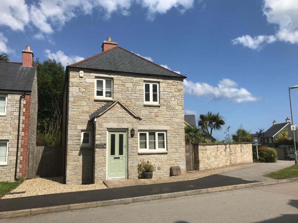a brick house with a green door on a street at Starfish Cottage- private beach access- dog friendly in Charlestown