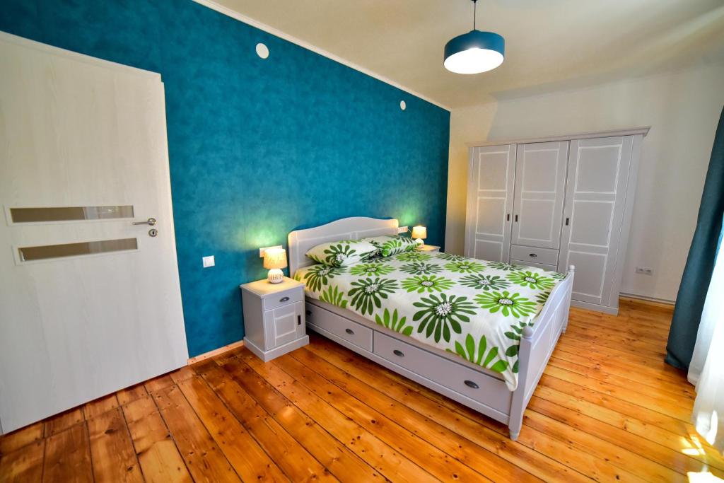 a bedroom with a bed and a blue wall at Old City Apartment in Sibiu