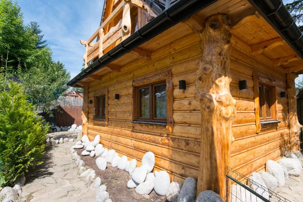 una cabaña de madera con estatuas blancas delante de ella en domek góralski, en Zakopane