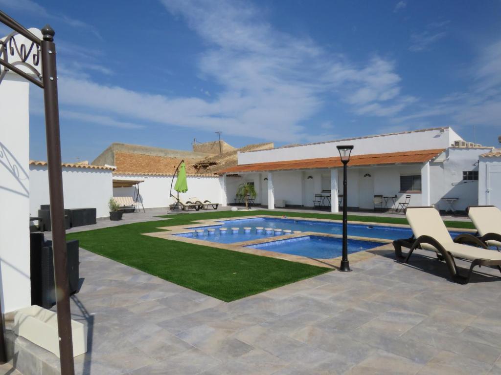a villa with a swimming pool and a patio at B&B Finca la Manchica in Cartagena