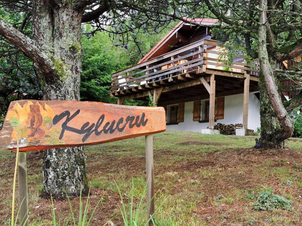 una señal frente a una casa con un árbol en Chalet Kylucru 6 personnes classé 2 étoiles en Xonrupt-Longemer
