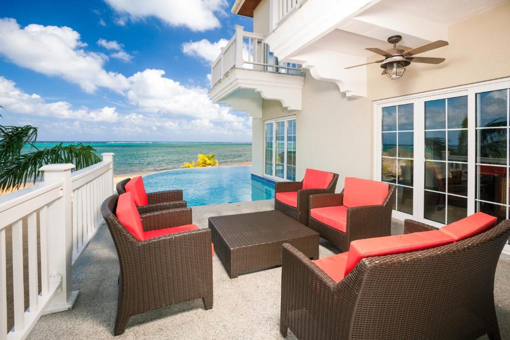 a patio with chairs and a pool and the ocean at Lawson Rock - Seahorse 104 Condo in Sandy Bay