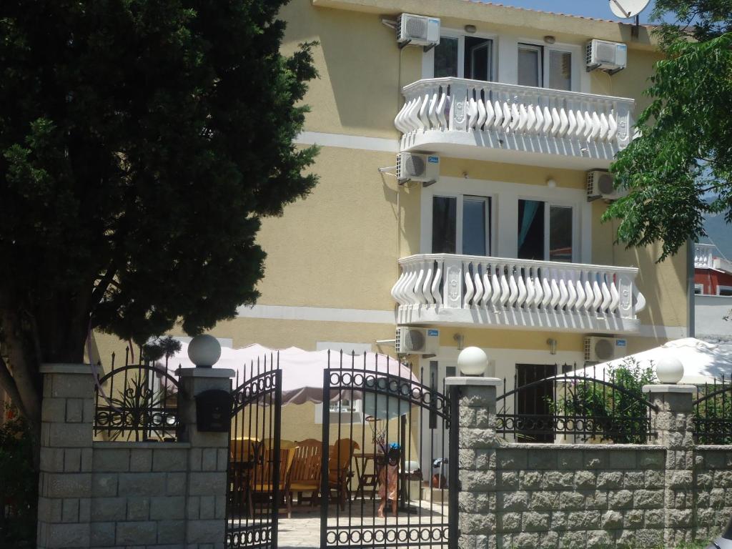 een gebouw met een hek en een gebouw met een balkon bij Apartments Beba Zalad in Sutomore
