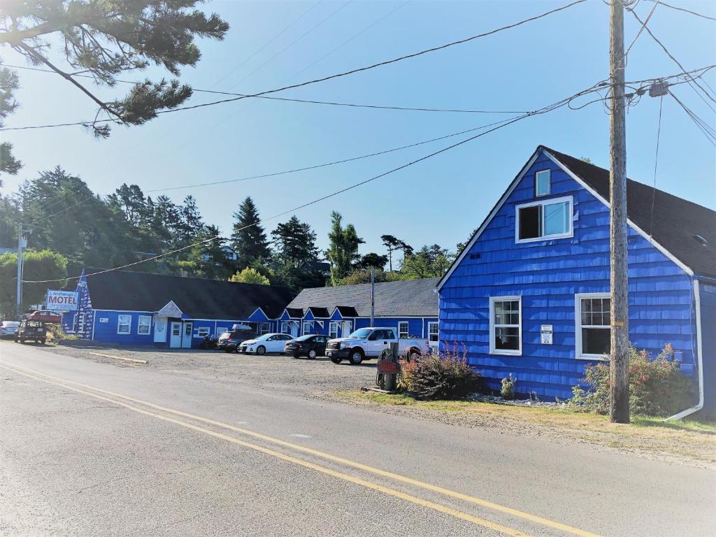 een blauw huis aan de kant van een straat bij The Anchorage Motel in Pacific City