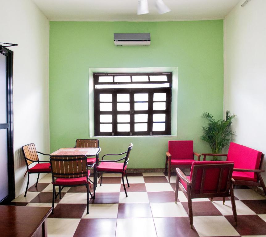 Habitación con mesa, sillas y ventana en Casa NE en Mérida