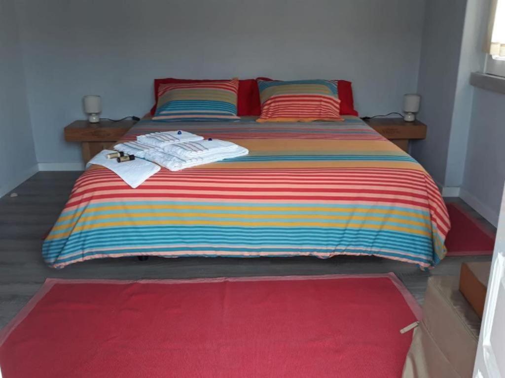 a bedroom with a large bed with a colorful blanket at Casa da Maria in Alcobaça