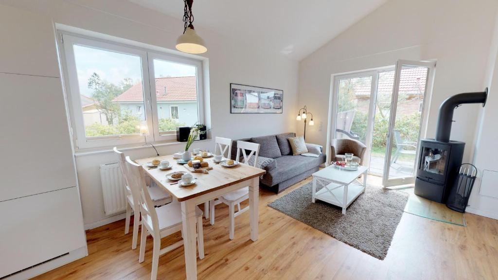 ein Wohnzimmer mit einem Tisch und einem Sofa in der Unterkunft Feriendorf Südstrand Haus 40 in Pelzerhaken