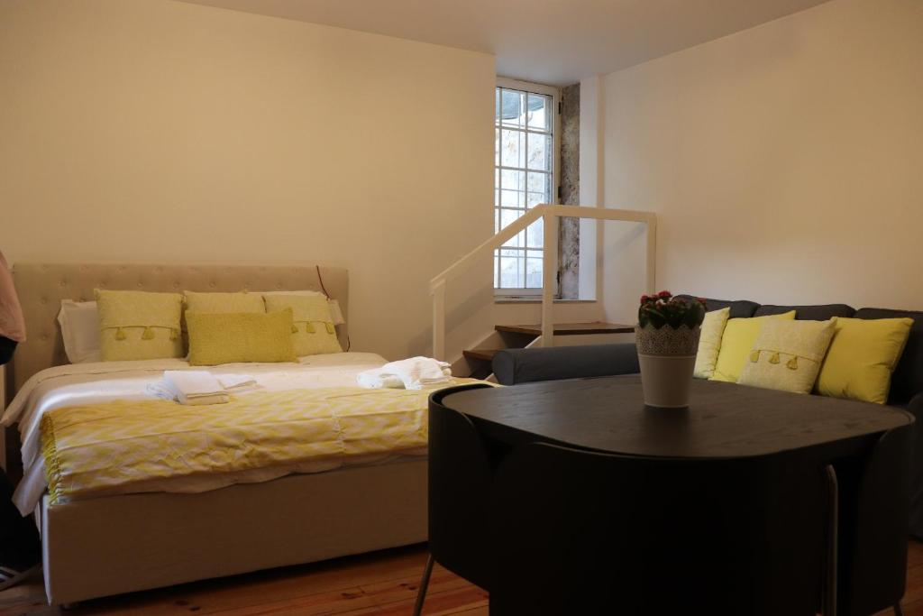 波多的住宿－Great & Cosy Foz Velha，一间卧室配有一张床和一张带黄色枕头的桌子