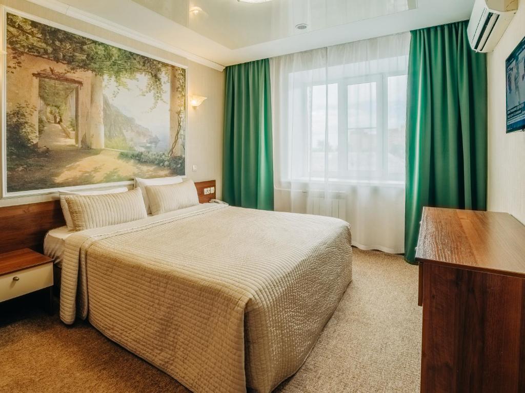 ハバロフスクにあるオーロラ ホテルのベッドと窓が備わるホテルルーム