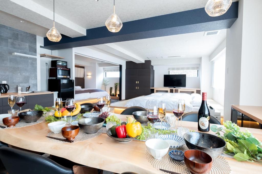 a dining room table with fruits and wine glasses at Hotel Kado Gosho-Minami Kyoto in Kyoto