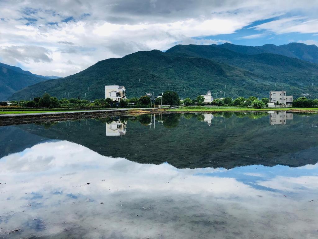 吉安的住宿－稻香緣民宿，一大片水体,背景是群山