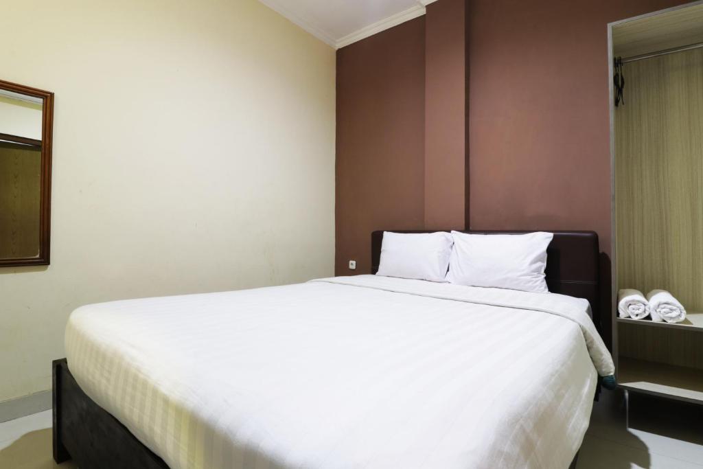 - une chambre avec un grand lit et des draps blancs dans l'établissement Hotel Istana Bungur, à Jakarta